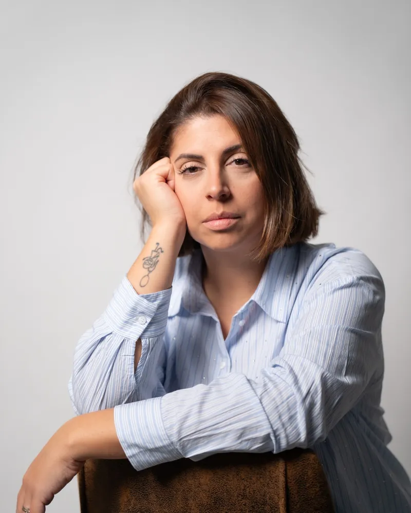 Antonella Sabato seduta, una mano vicino al viso